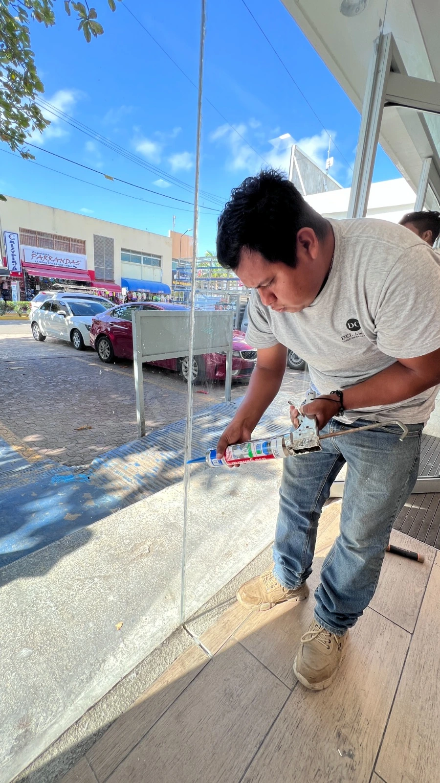 Técnico aplicando sellador de silicón en cancelería